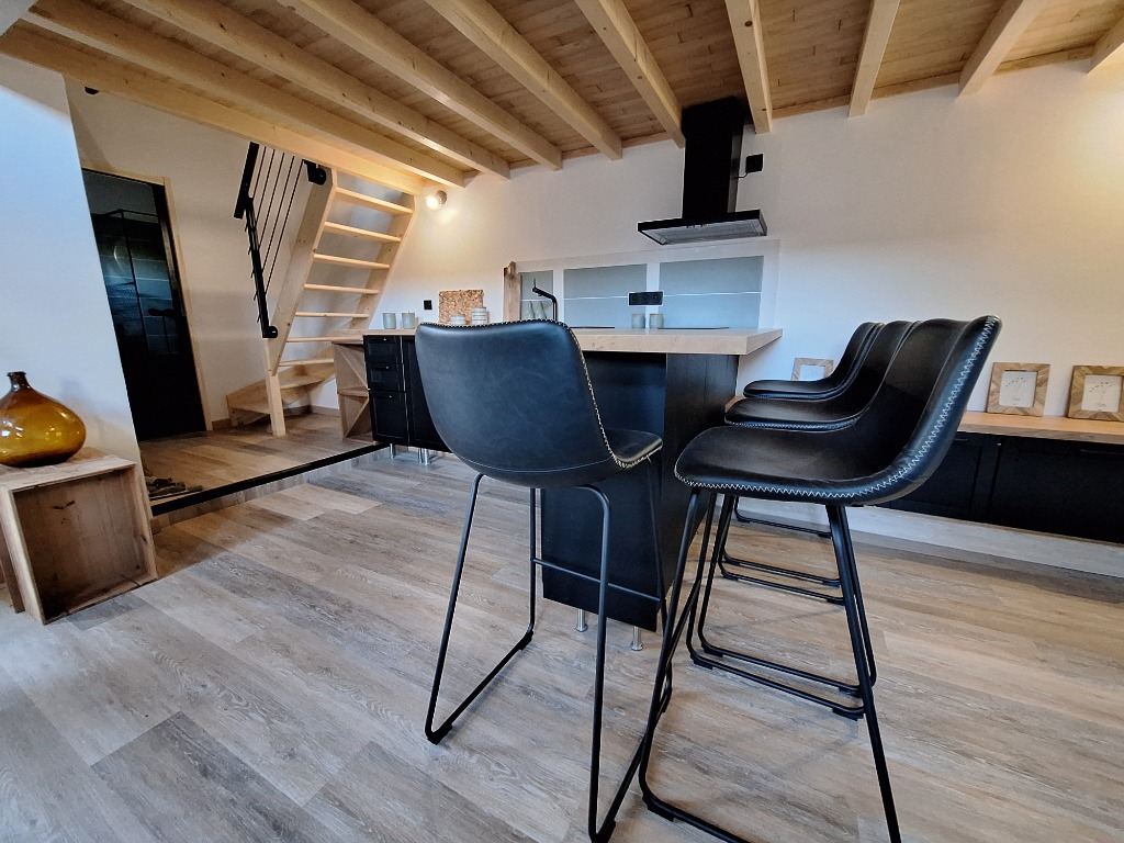 Intérieur du lodge avec cuisine et charpente apparente
